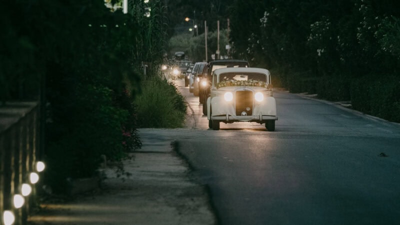 Vintage wedding car arriving at Costa Navarino in the evening