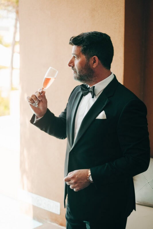Groom enjoying champagne before his wedding ceremony in Pylos