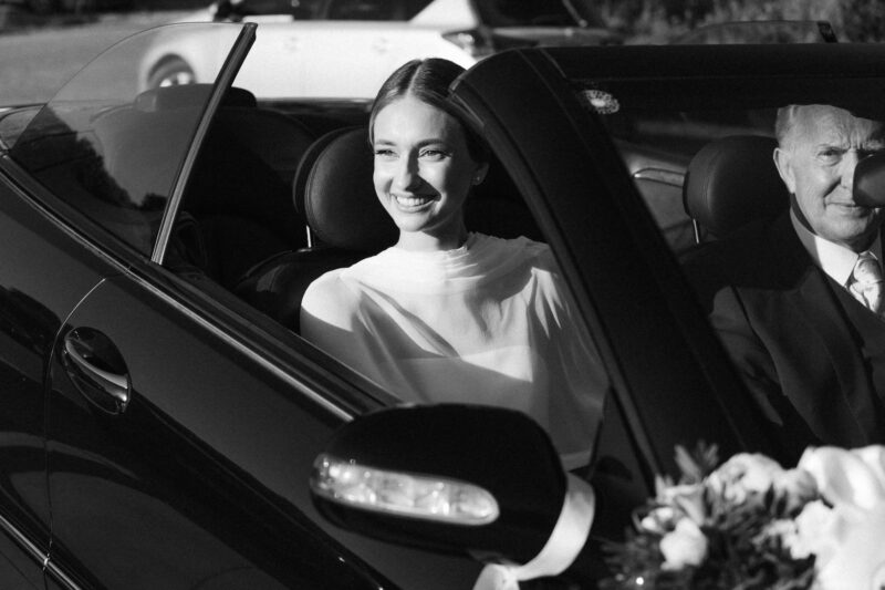 Bride and father in a luxury convertible car arrive in wedding.