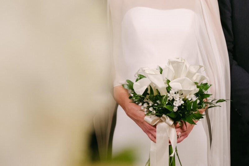 Bride holding a white calla lily bouquet at her wedding.