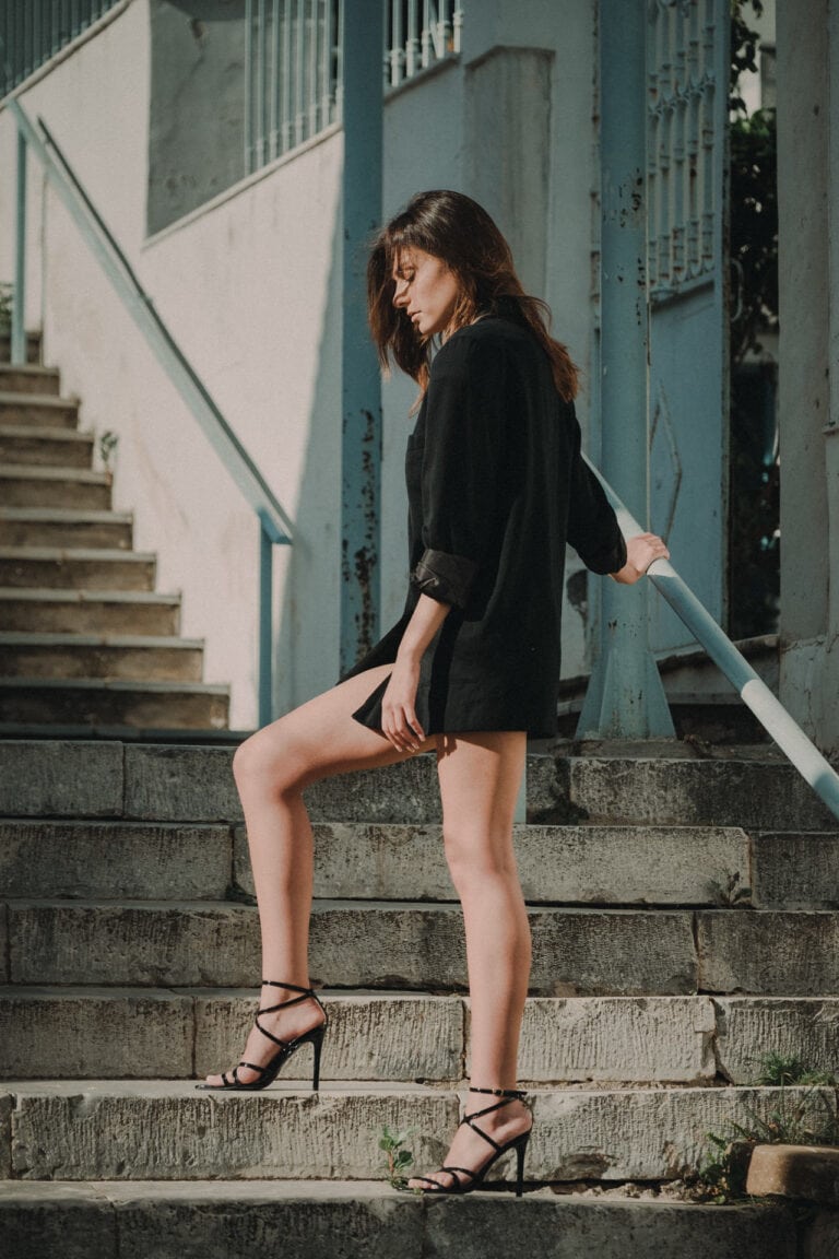 Φωτογραφία κοπέλας με υπέροχα πόδια πάνω σε σκάλια πόλης