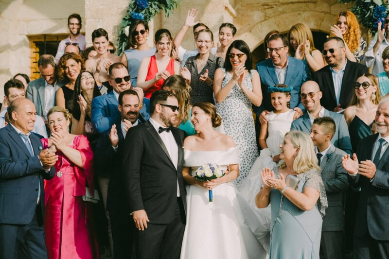 Newlyweds leaving the historic church at Niokastro surrounded by celebrating guests