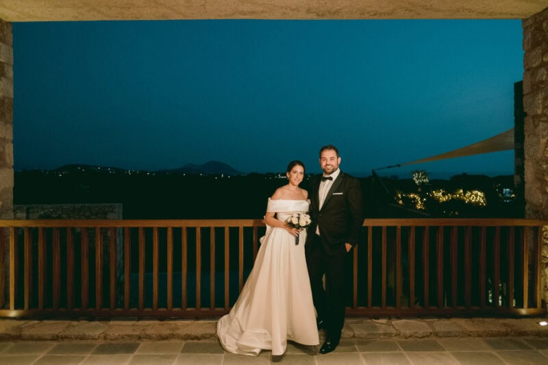 Bride and groom together on a terrace at Costa Navarino after sunset