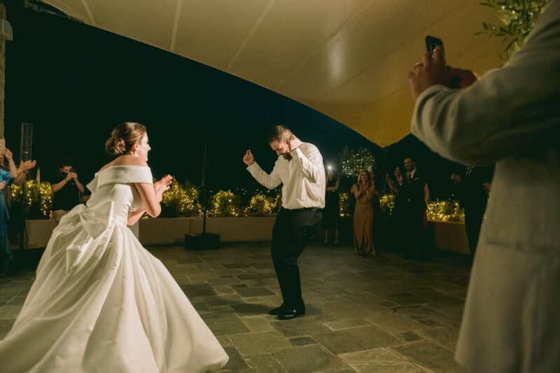 Bride and groom dancing outdoors during their evening wedding reception at Costa Navarino