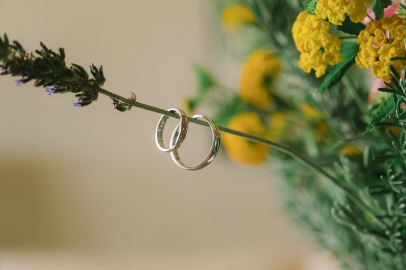 Wedding rings suspended among colorful flowers during preparations at Costa Navarino