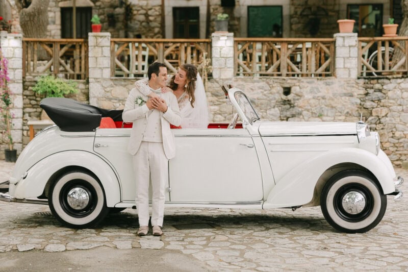 Bride and groom with a vintage wedding car in Mani Greece