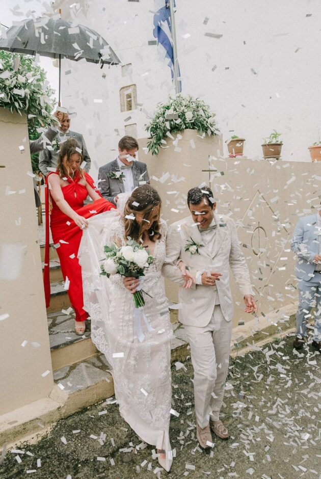 Newlyweds leaving the church surrounded by wedding confetti