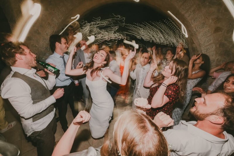 Energetic wedding party dancing under the lights in Mani